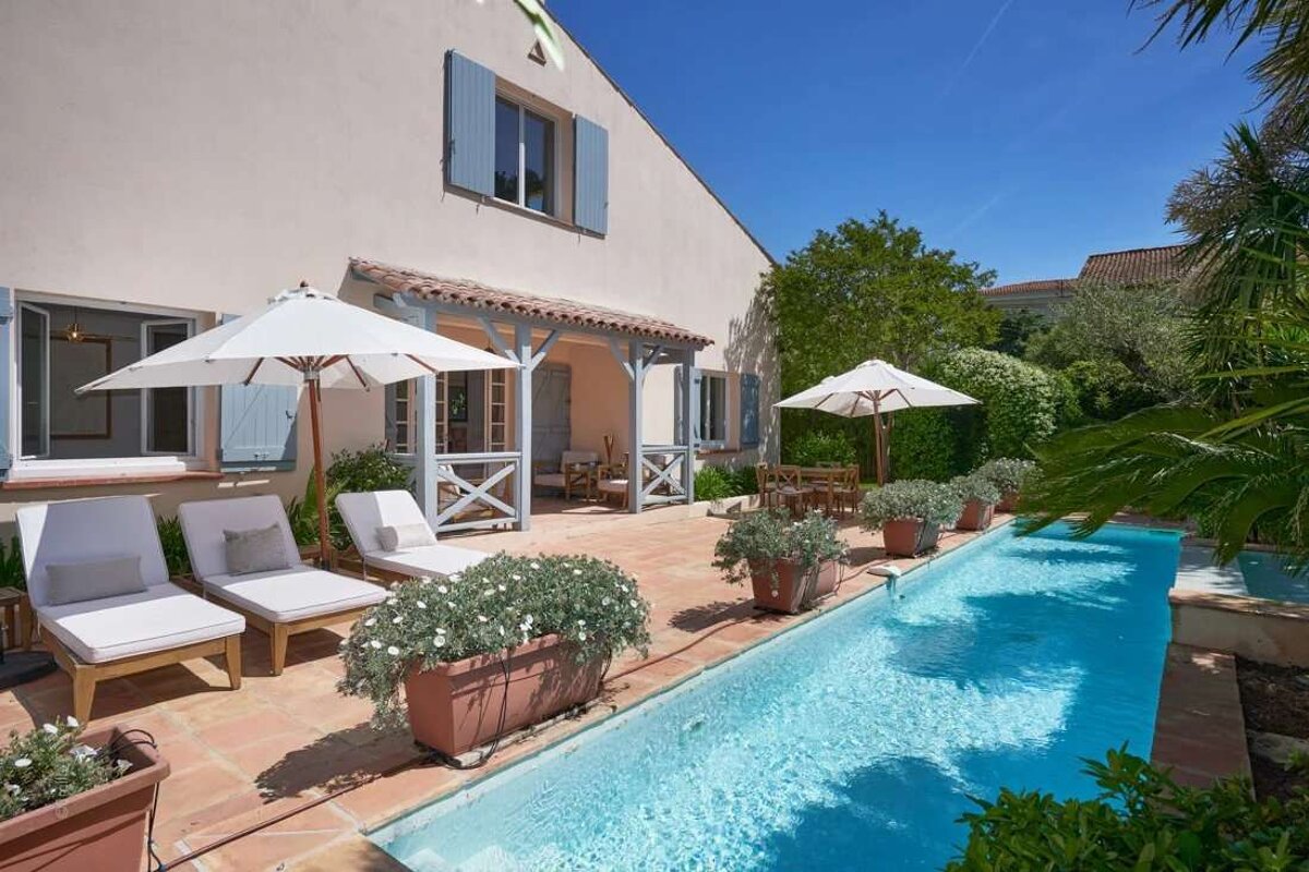 A house with a large swimming pool in front of it