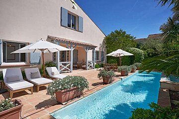 A house with a large swimming pool in front of it