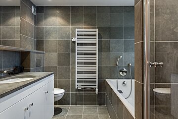 A bathroom with a bathtub and a towel rack