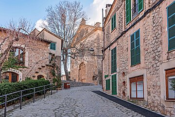 A narrow cobblestone street with a building that says ' oficina ' on it