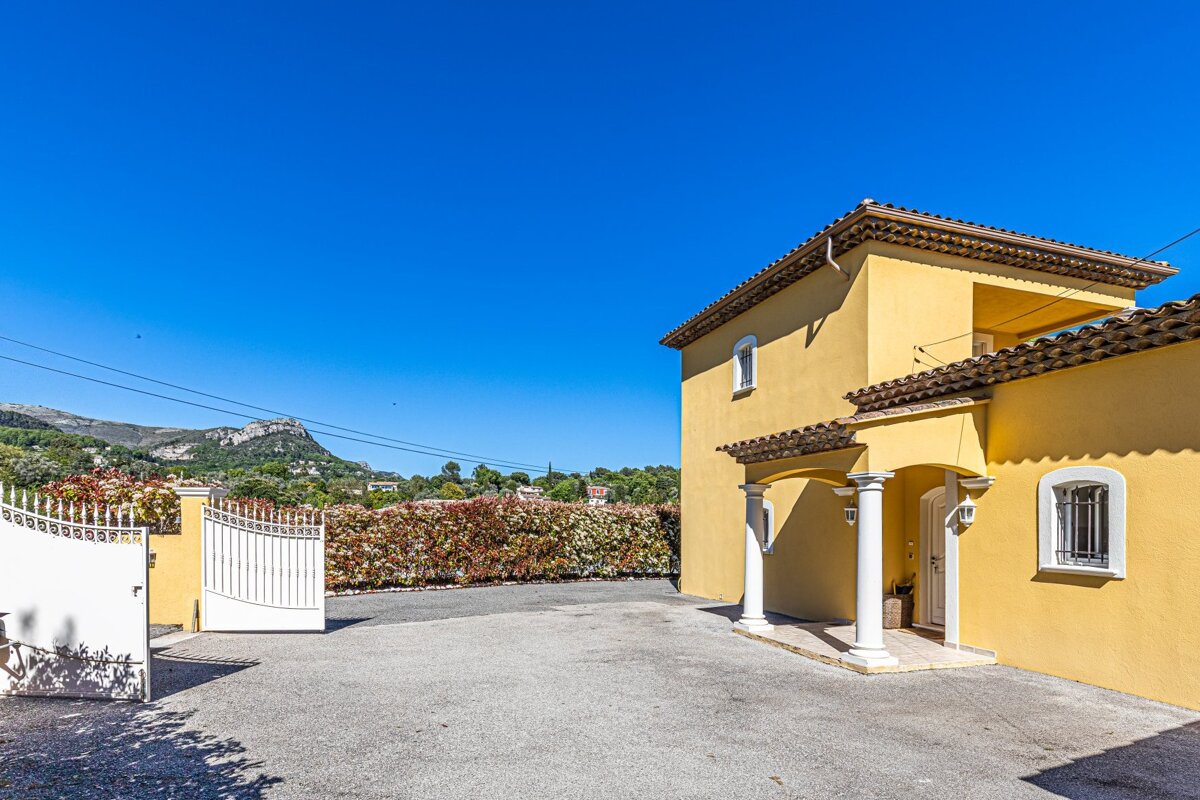 A yellow house with a white gate in front of it