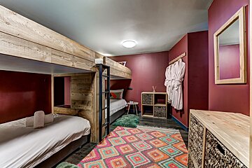 A bedroom with bunk beds and a rug on the floor