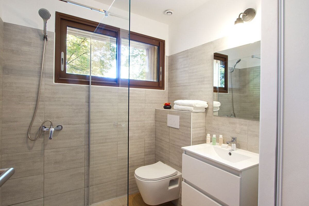 A bathroom with a toilet a sink and a window