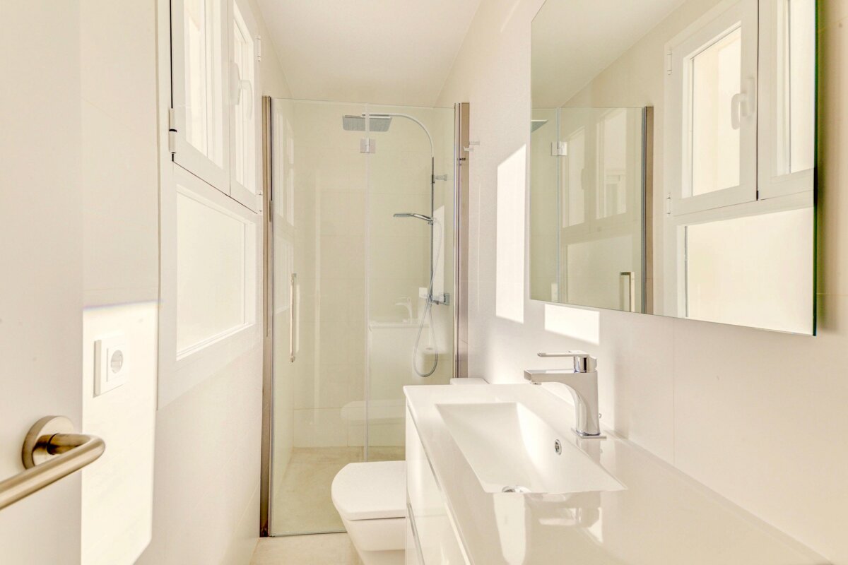 A bathroom with a toilet a sink and a mirror