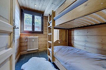 A bedroom with bunk beds and a radiator