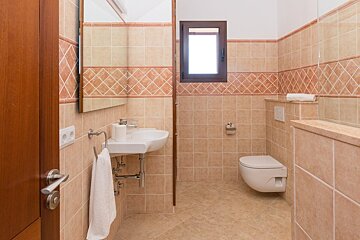 A bathroom with a sink and toilet and a window
