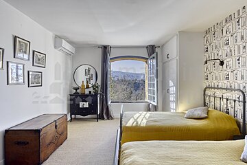 A bedroom with two beds a dresser and a window