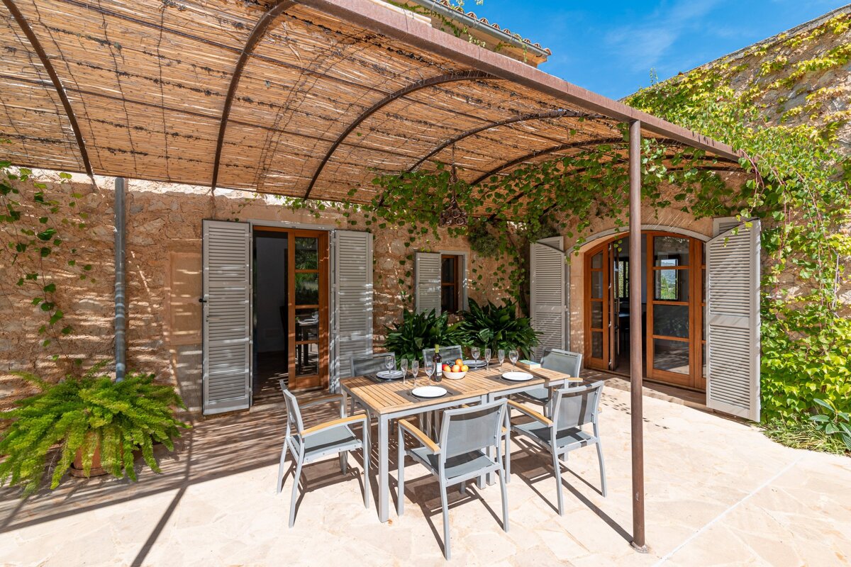 A patio with a table and chairs under a pergola