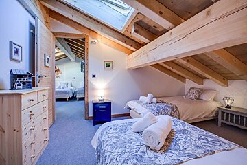A bedroom with two beds and a blue nightstand