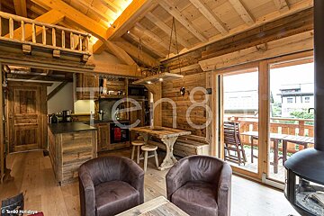 A living room with a table and chairs and a sign that says ten80 holidays