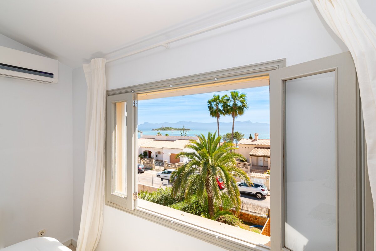 A window with a view of the ocean and palm trees