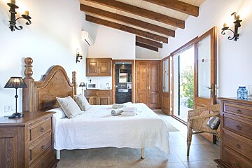 A bedroom with a large bed and a dresser