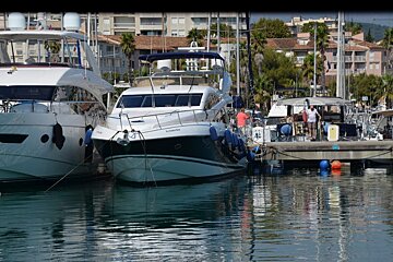 Several boats are docked in a harbor one of which says volvo on the side