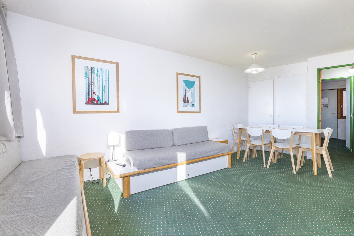 A living room with a couch a table and chairs