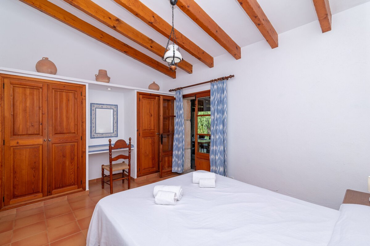 A bedroom with a large bed and a mirror on the wall