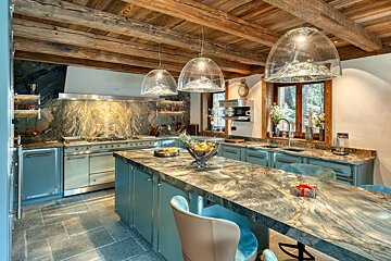 A kitchen with stainless steel appliances and marble counter tops
