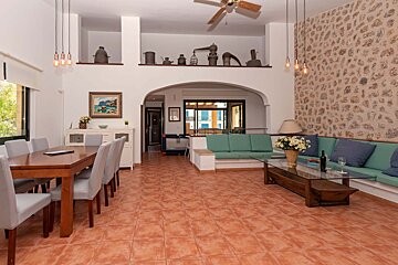 A living room with a table and chairs and a ceiling fan