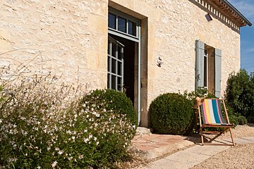 A striped chair sits in front of a stone building