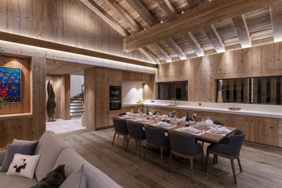 A dining room with a long table and chairs