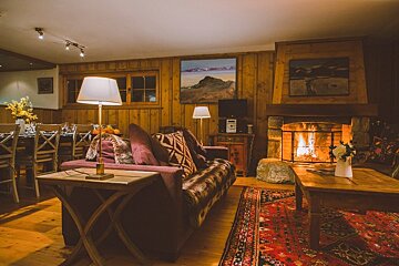 A living room with a purple couch and a fireplace