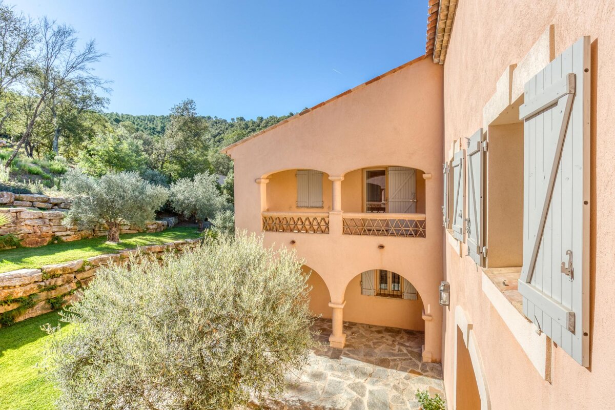 A house with a balcony and shutters on the windows