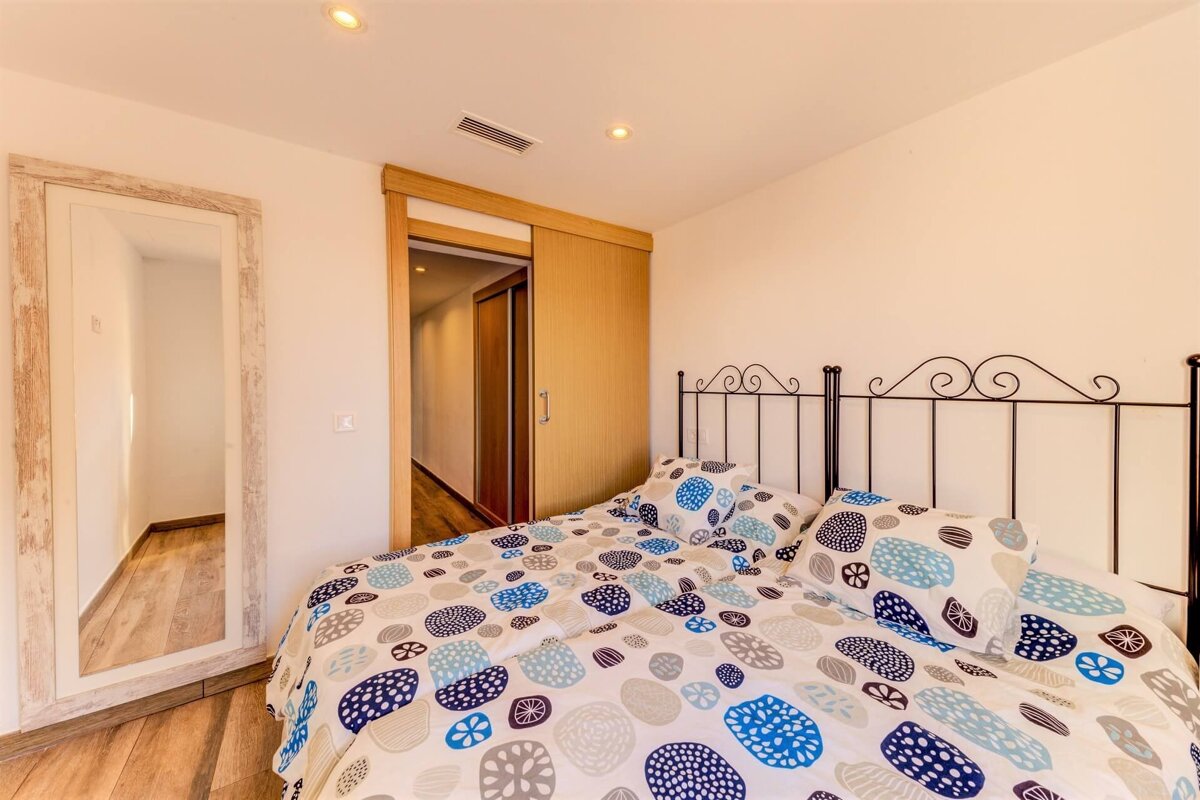 A bedroom with a bed and a large mirror