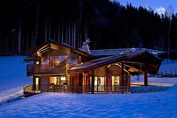 A house in the snow with a mountain in the background