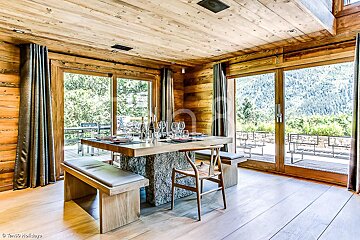 A wooden dining room with a table and chairs