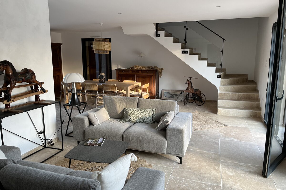 A living room with a couch and stairs in the background