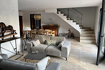 A living room with a couch and stairs in the background