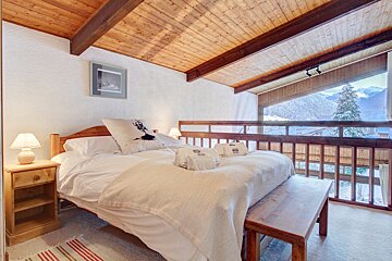 A bedroom with a large bed and a view of the mountains