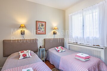 A bedroom with two beds and a picture on the wall that says made in provence