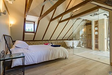 A bedroom with a bed and a bathtub in it