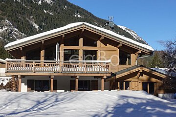 A large wooden house is surrounded by snow and has the word tenbo on it