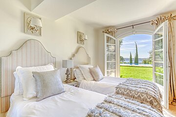 A bedroom with two beds and a large window
