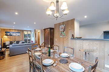 A dining room table with a bottle of wine on it