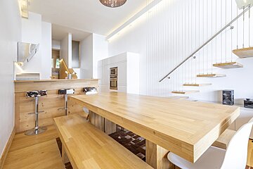 A kitchen with a wooden table and stools