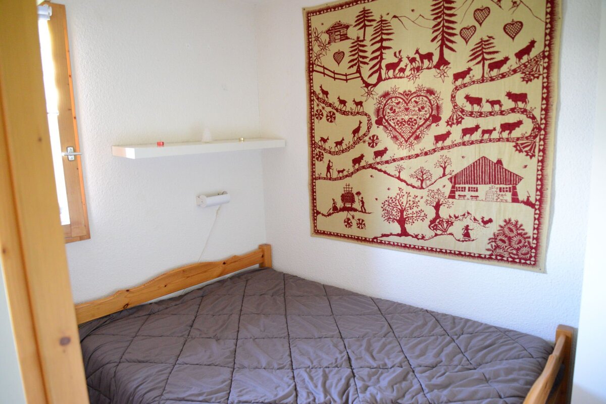 A bedroom with a bed and a tapestry on the wall