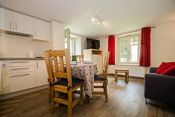 A kitchen with a table and chairs and a couch