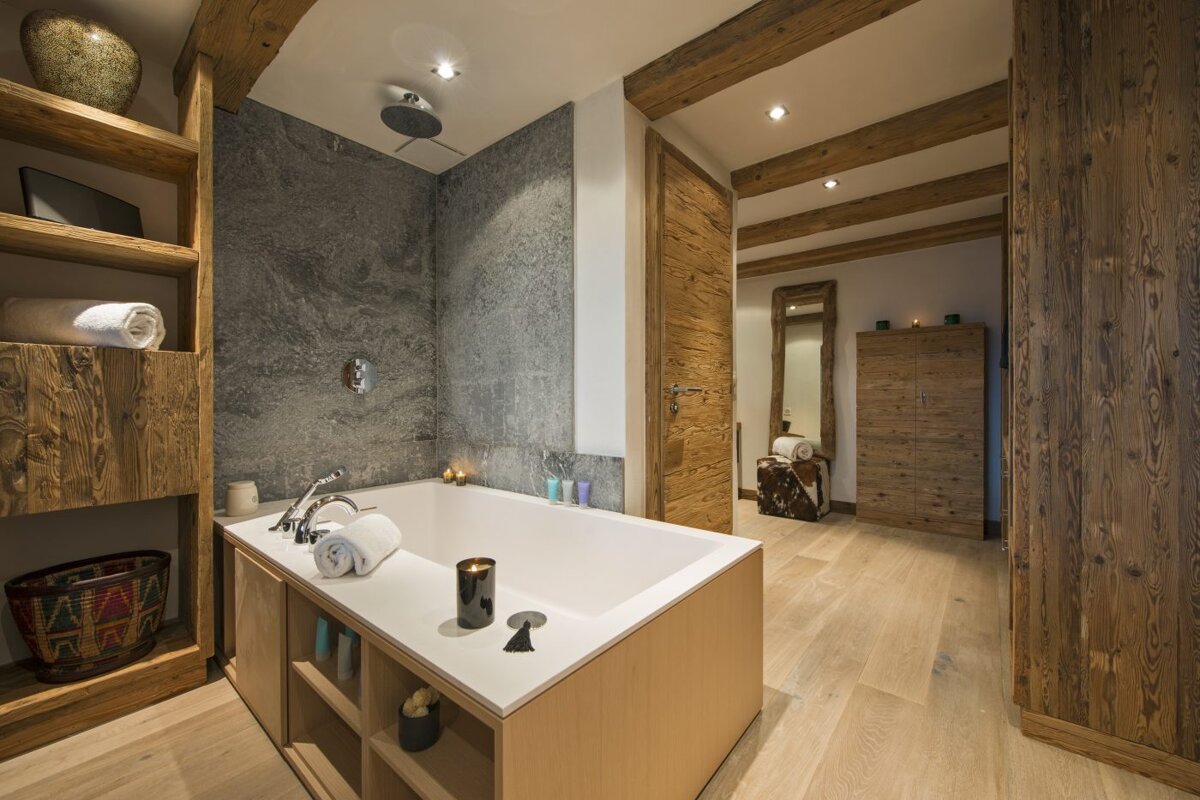 A bathroom with a bathtub and wooden shelves