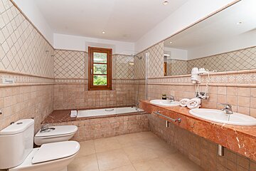 A bathroom with two sinks and a toilet