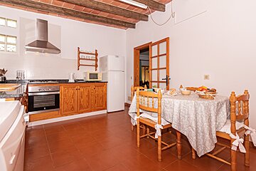 A kitchen with a table and chairs and a refrigerator