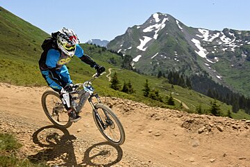 A person riding a bike on a trail with a mountain in the background