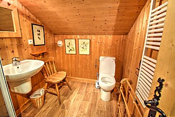 A bathroom with wooden walls and a toilet