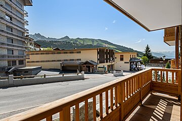 A balcony with a view of a building and mountains