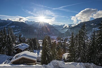 The sun is shining through the clouds over the mountains