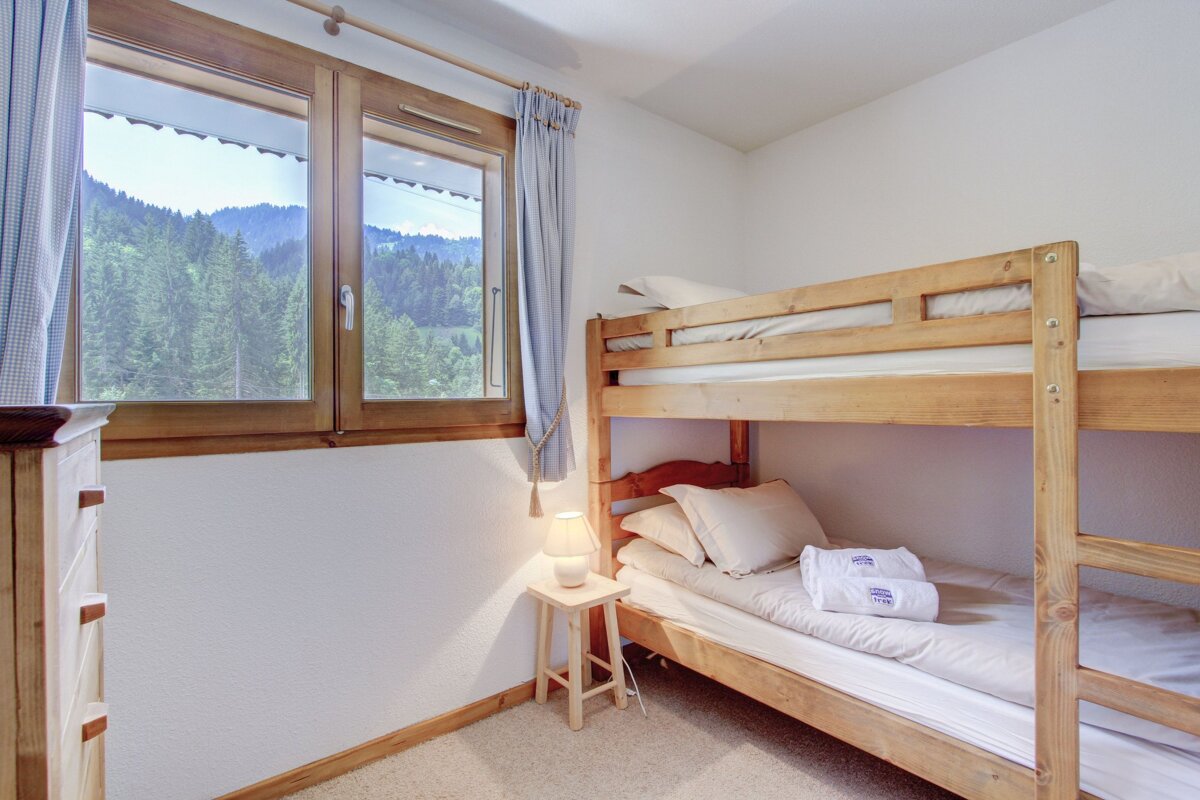 A bunk bed in a bedroom with a view of the mountains