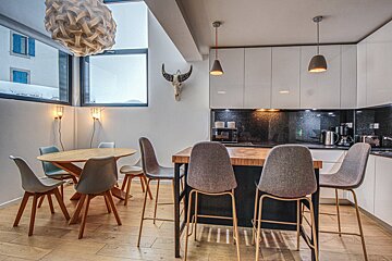 A kitchen with a table and chairs and a skull on the wall