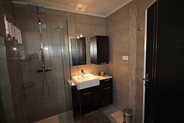 A bathroom with a sink and a walk in shower