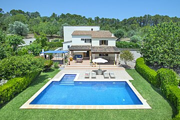 A house with a large swimming pool in front of it